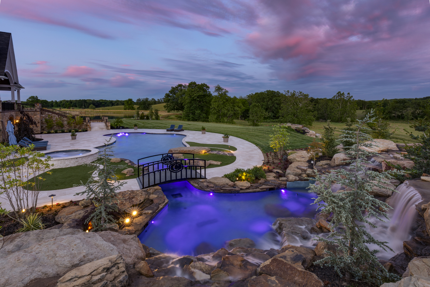 Freeform pool installed with a natural stone waterfall.