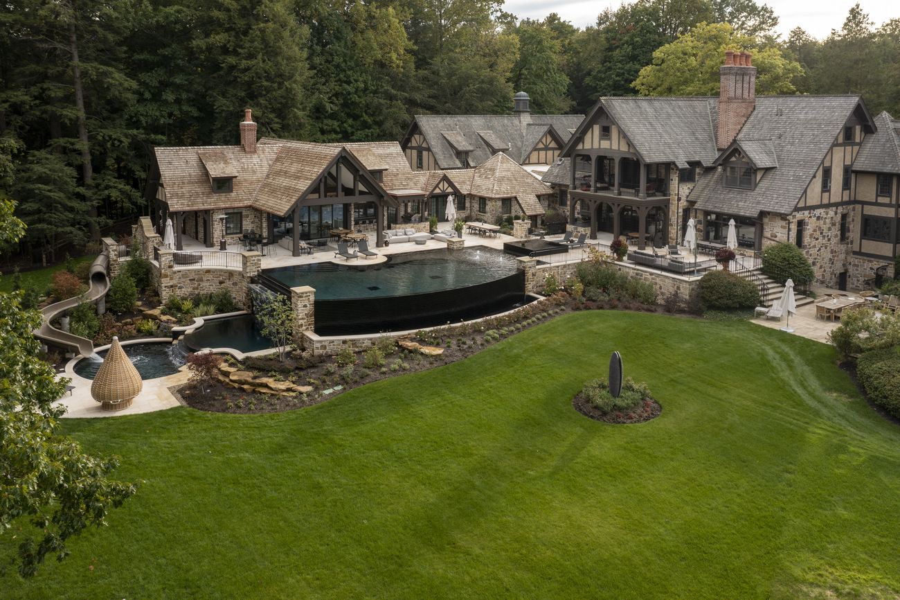 Aerial view of large residential property with freeform pool.