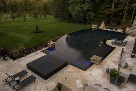 Freeform residential pools installed with blue lights.