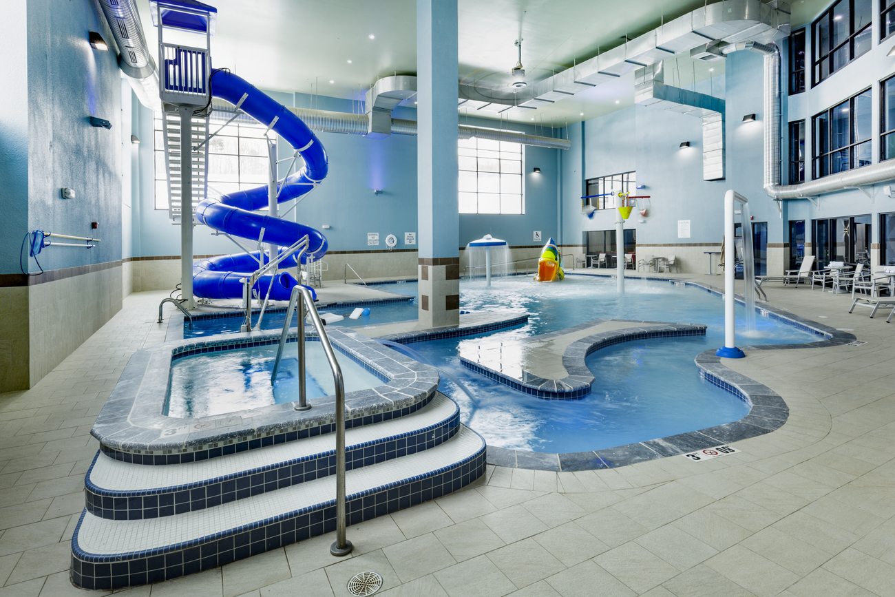 Indoor freeform pool with a blue slide.