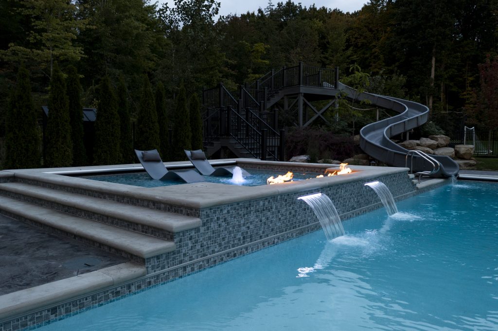 bespoke custom pool with large water slide next to the pool