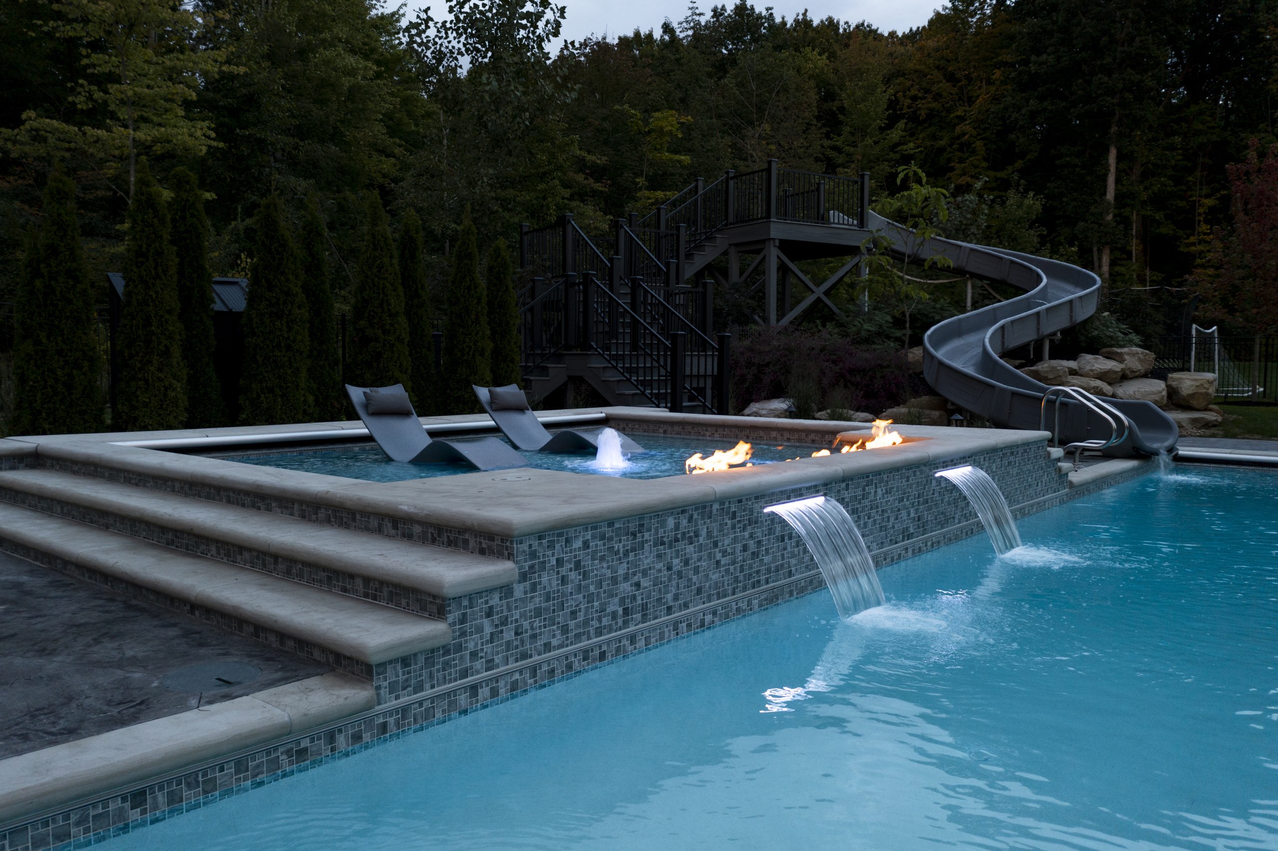 bespoke custom pool with large water slide next to the pool