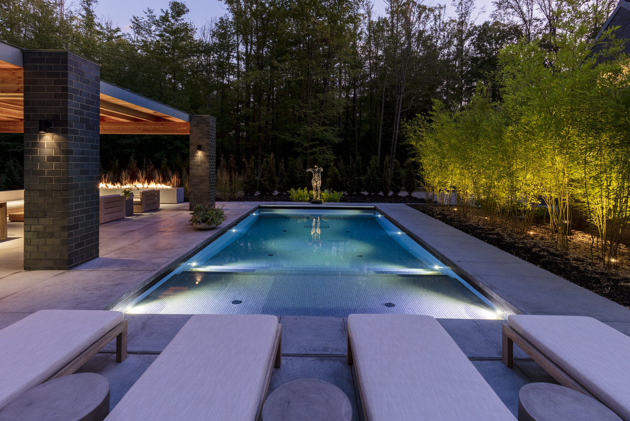 Small rectangular residential swimming pool at dusk.