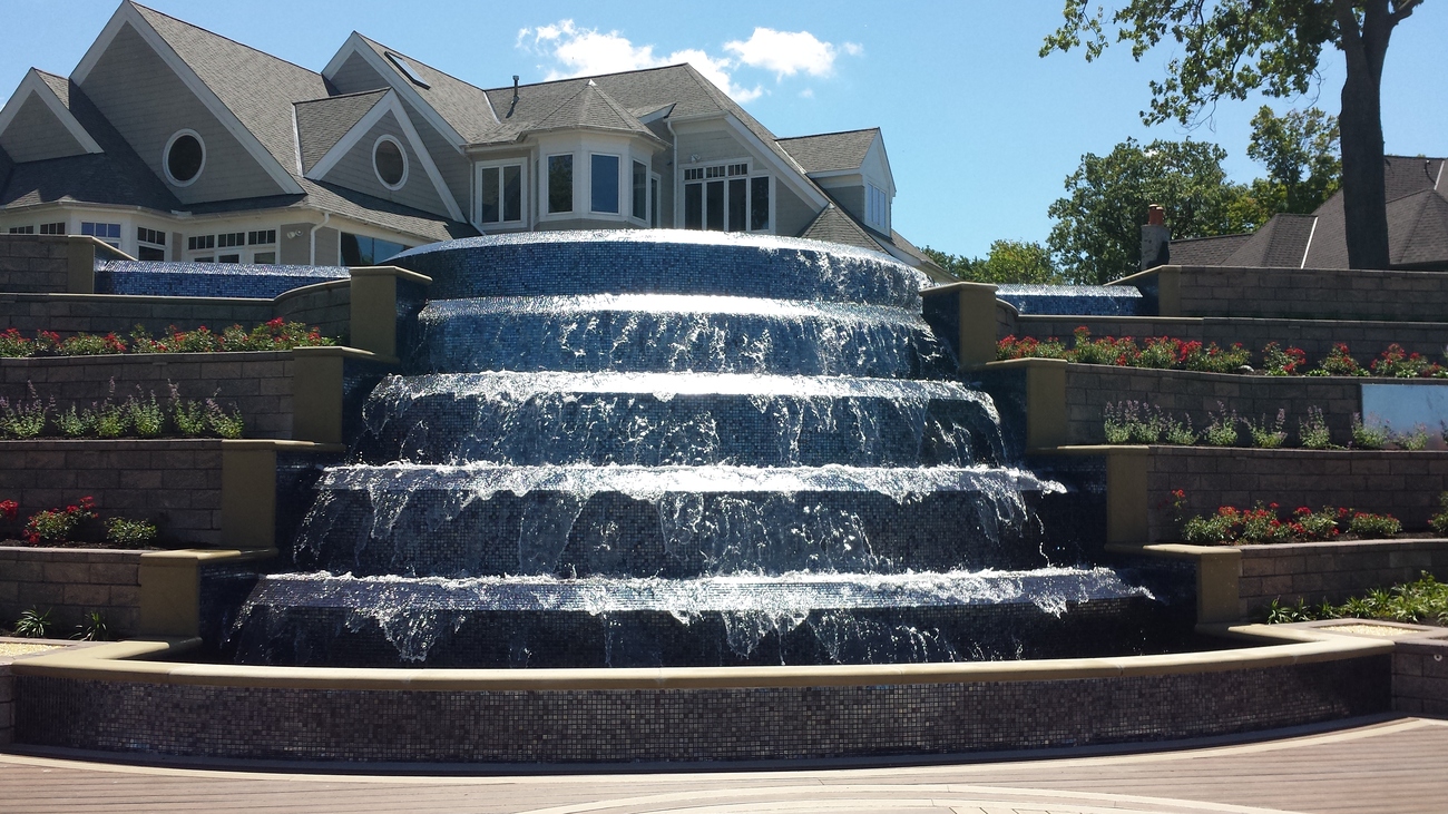 Close up of a fountain attached to a freeform pool.