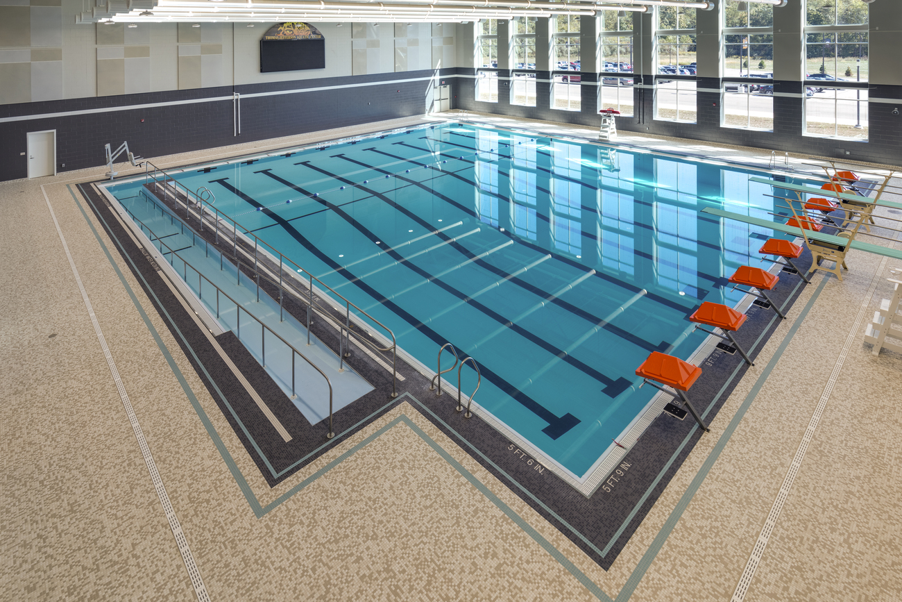 Side view of large school swimming pool with diving boards.