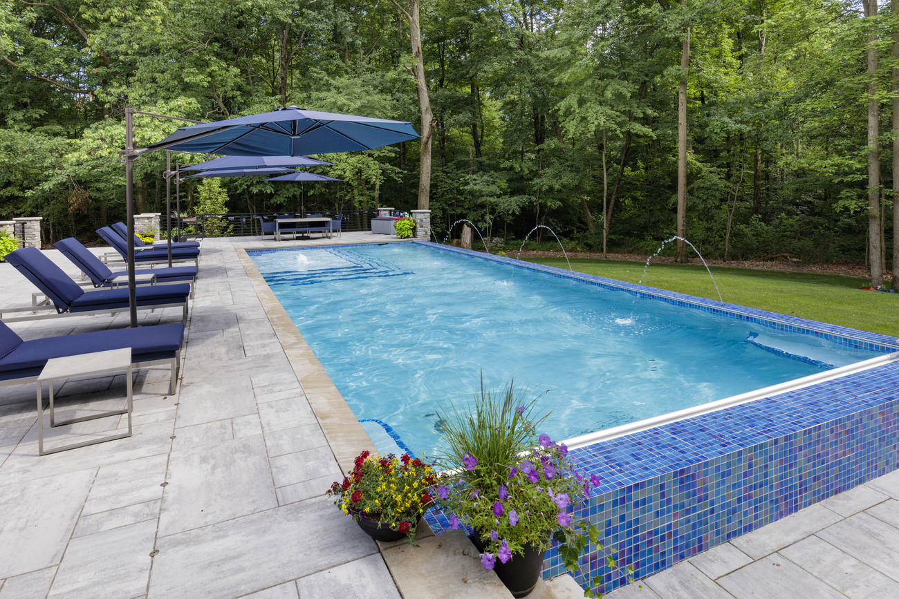 Rectangular residential pool installed with in-pool fountains.