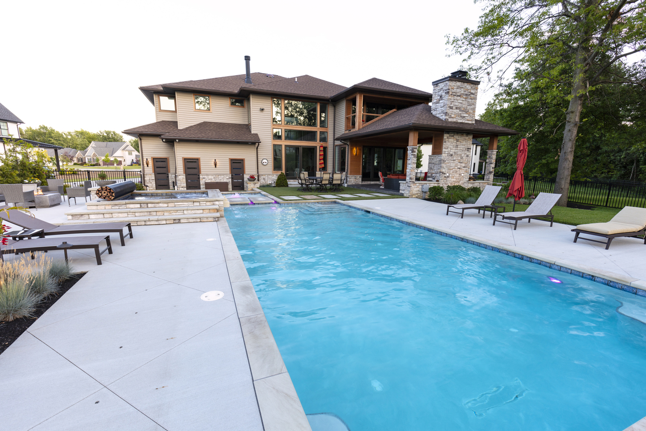 Large rectangular residential pool with stone patio.