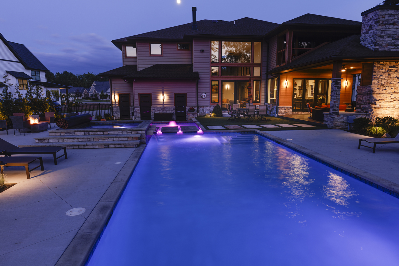 Large rectangular residential pool with purple lights.