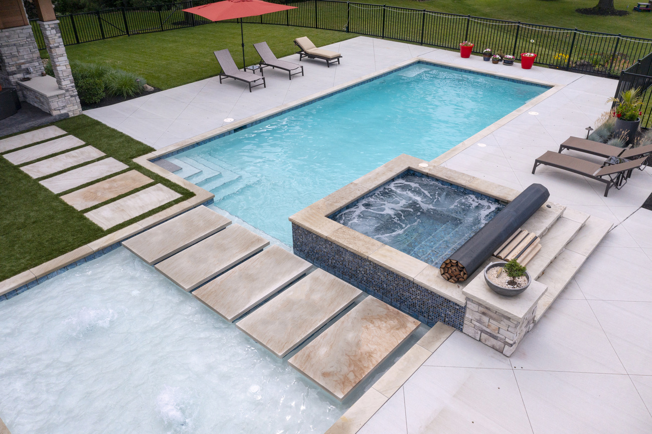 Rectangular residential pool with small rectangular hot tub.