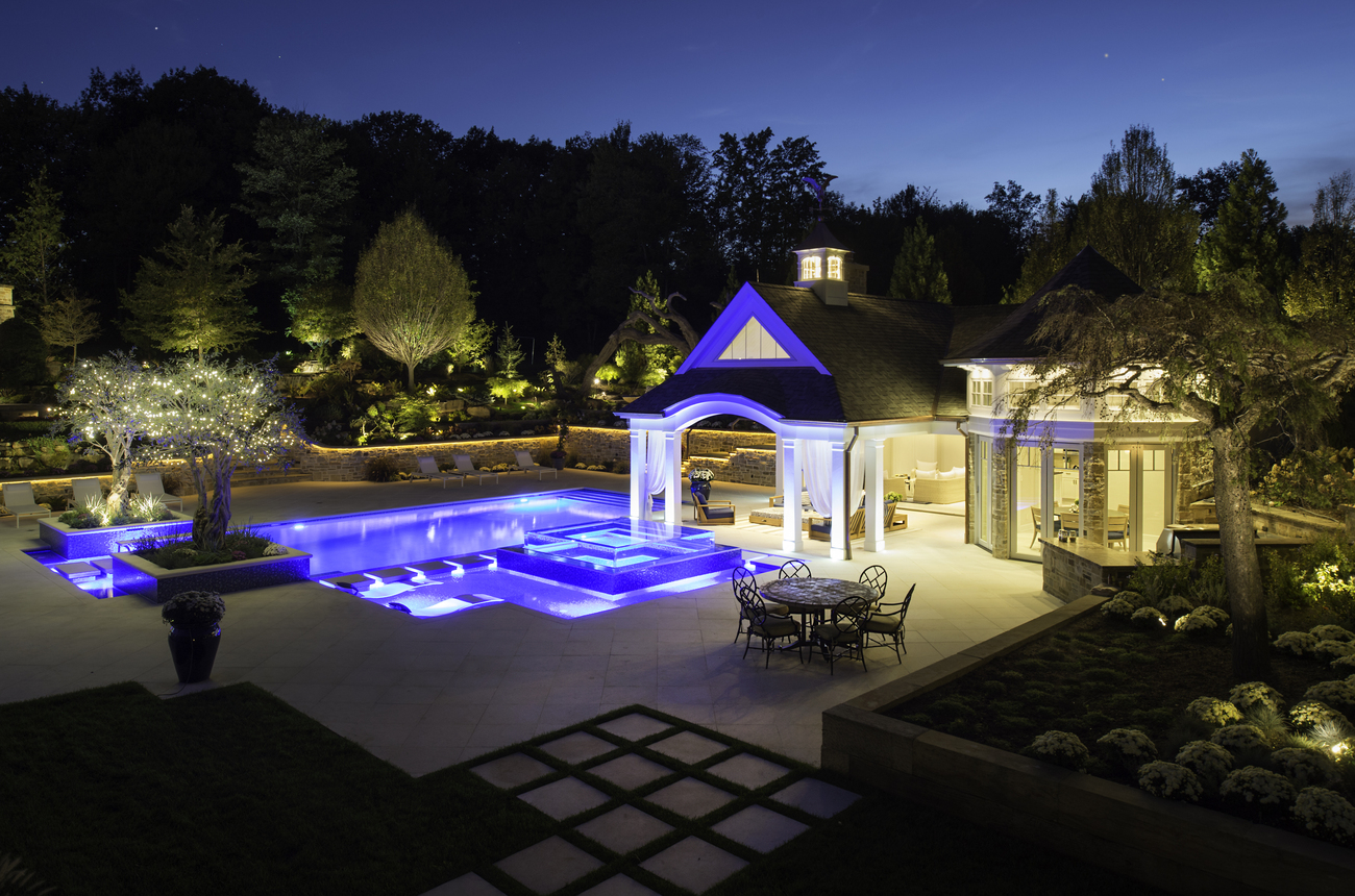 Side view of an outdoor geometric pool installed with blue lights.