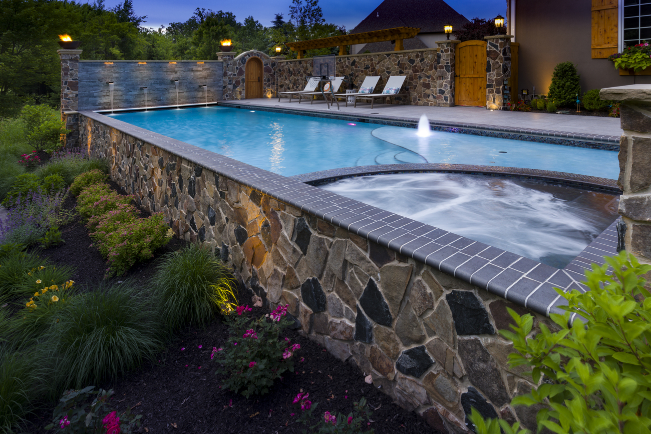 Side view of stone wall installed as part of a pool.