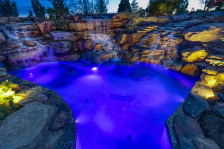 Residential freeform pool installed with stone fountains.