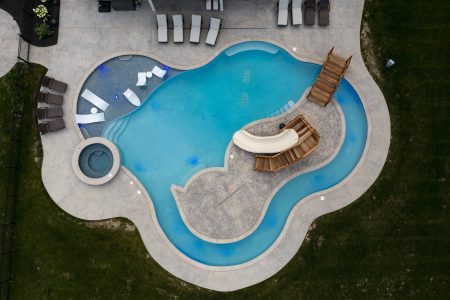 a birdseye view of a freeform swimming pool built for a family