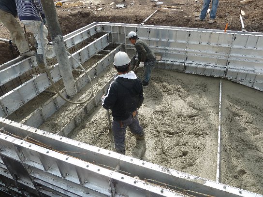 Concrete pool wall forms being filled | High Tech Pools